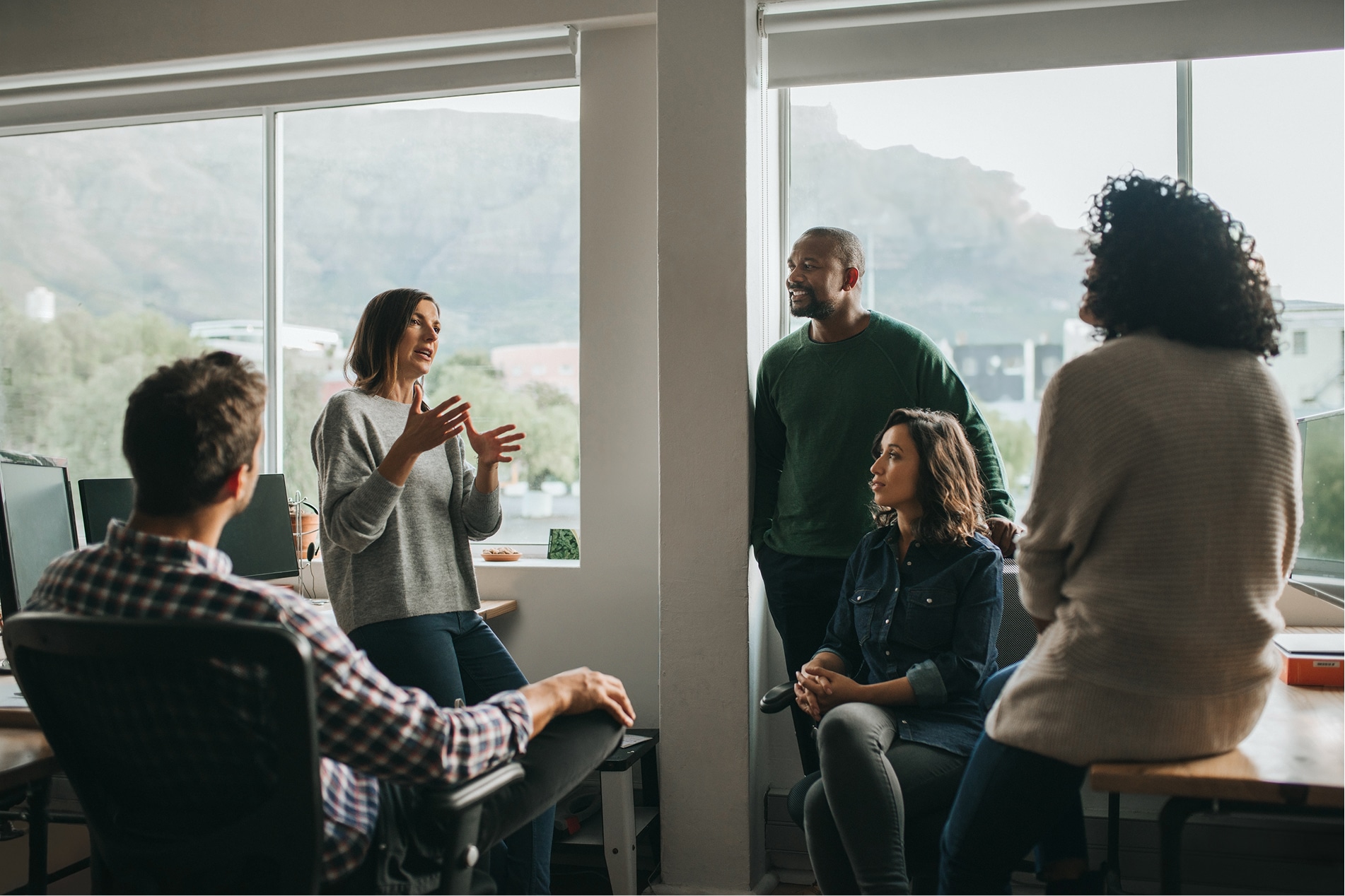 People in an office discussing in a circle.